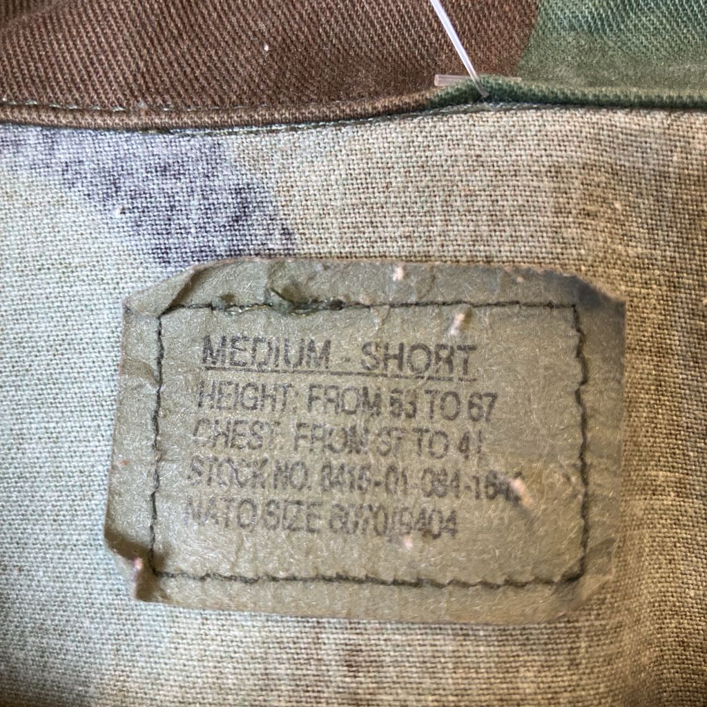 Fabric tag with size and measurement details on a textured fabric background