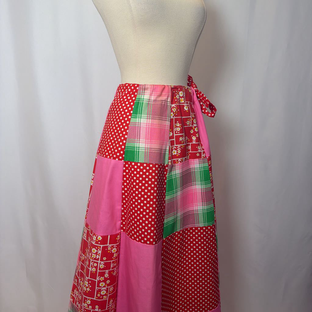 Patchwork skirt with red, green, and pink patterns on a mannequin against a white background