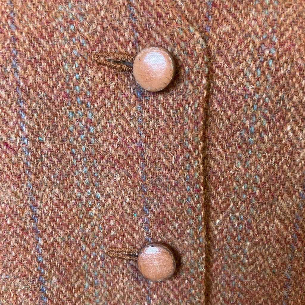 Close-up of a brown textured fabric with wooden buttons.