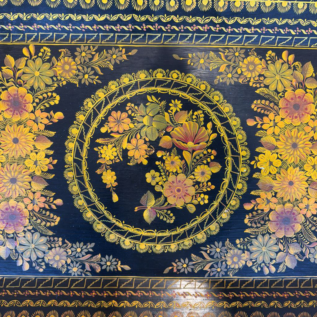 Decorative fabric with floral patterns and a central circular design on a blue background
