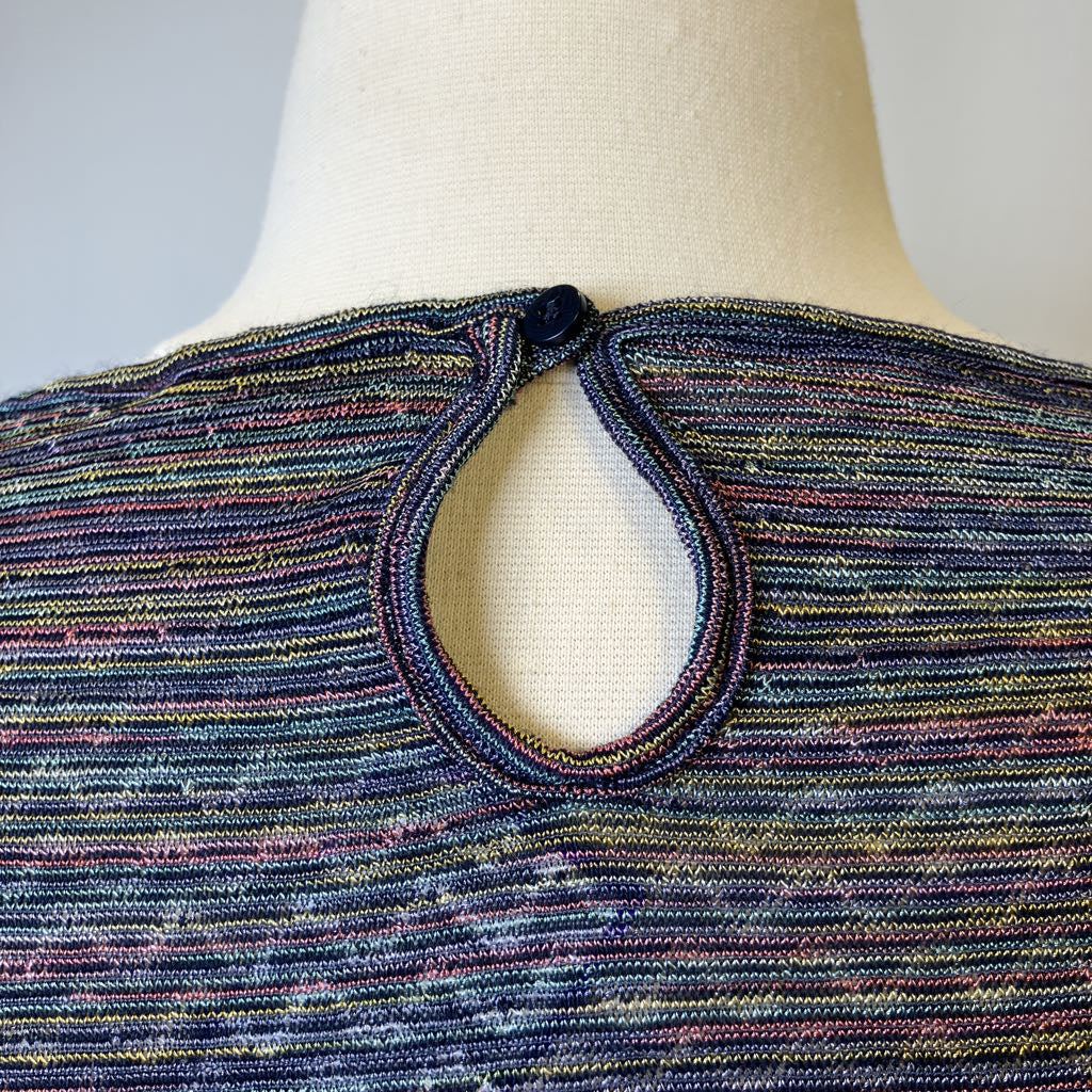 Multicolored knit garment on a mannequin with a plain background