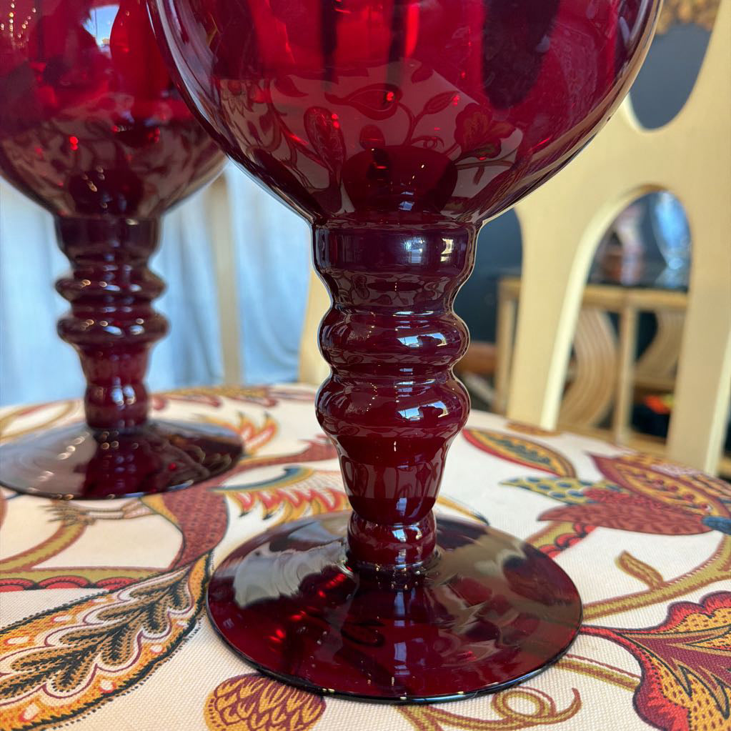 Red goblet on a patterned tablecloth with a blurred background