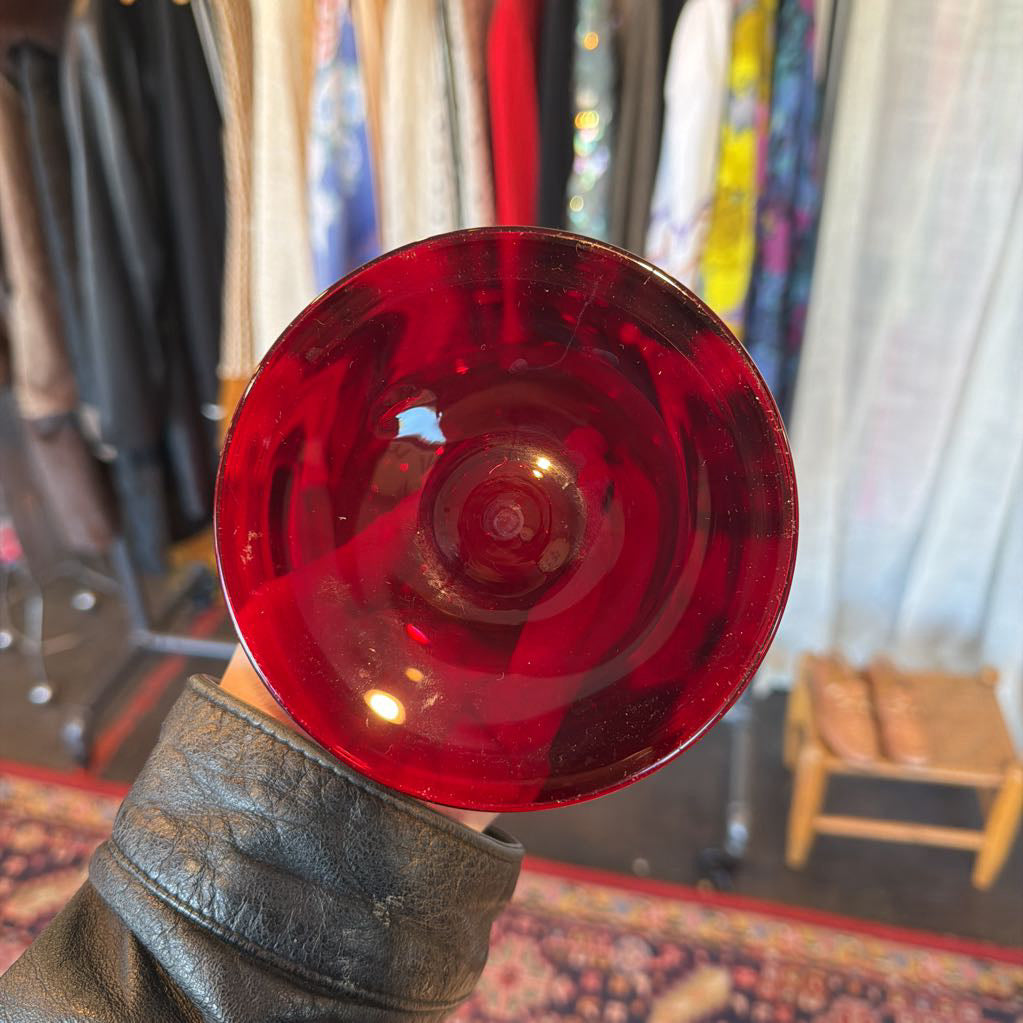 Red translucent object held by a person with a blurred indoor background