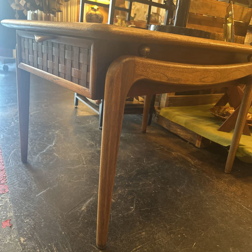 Wooden table with wicker sideboard against a dark floor.