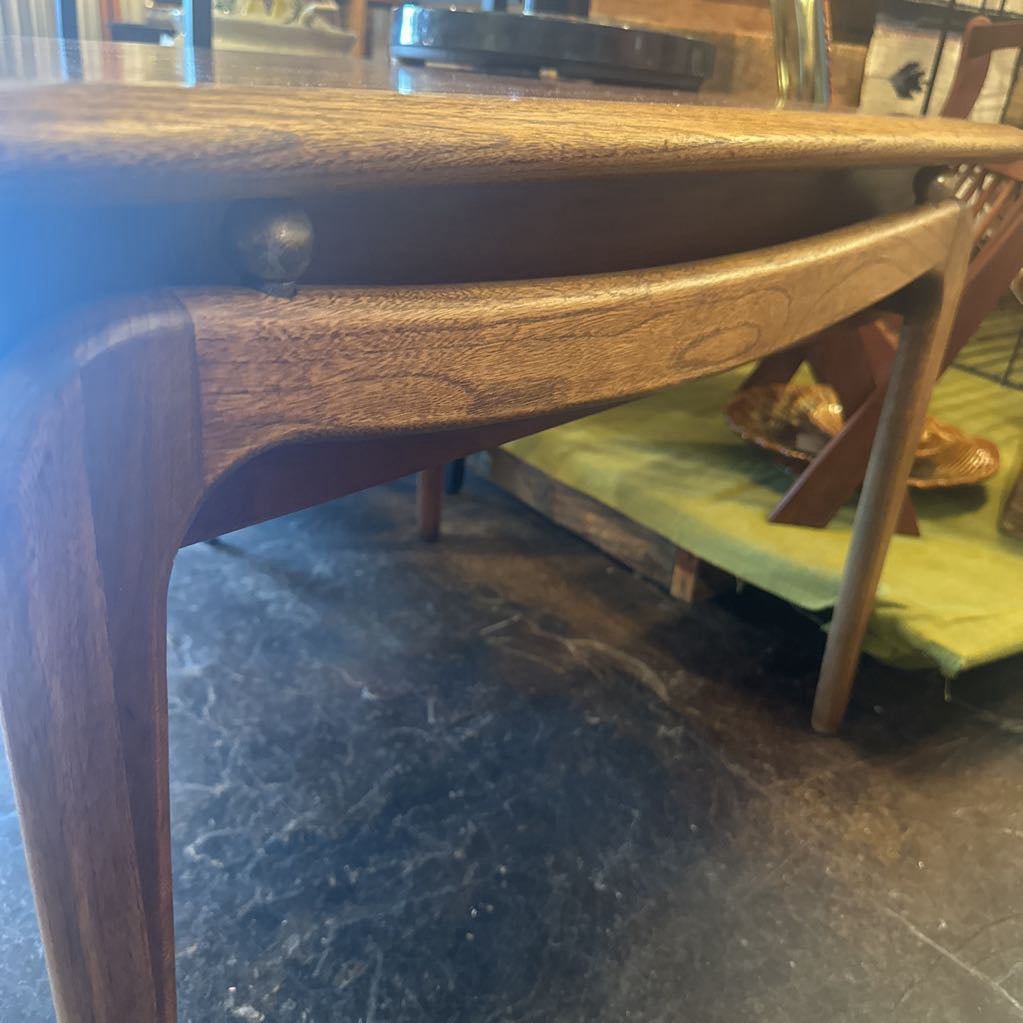 Wooden chair with a green cushion on a dark floor