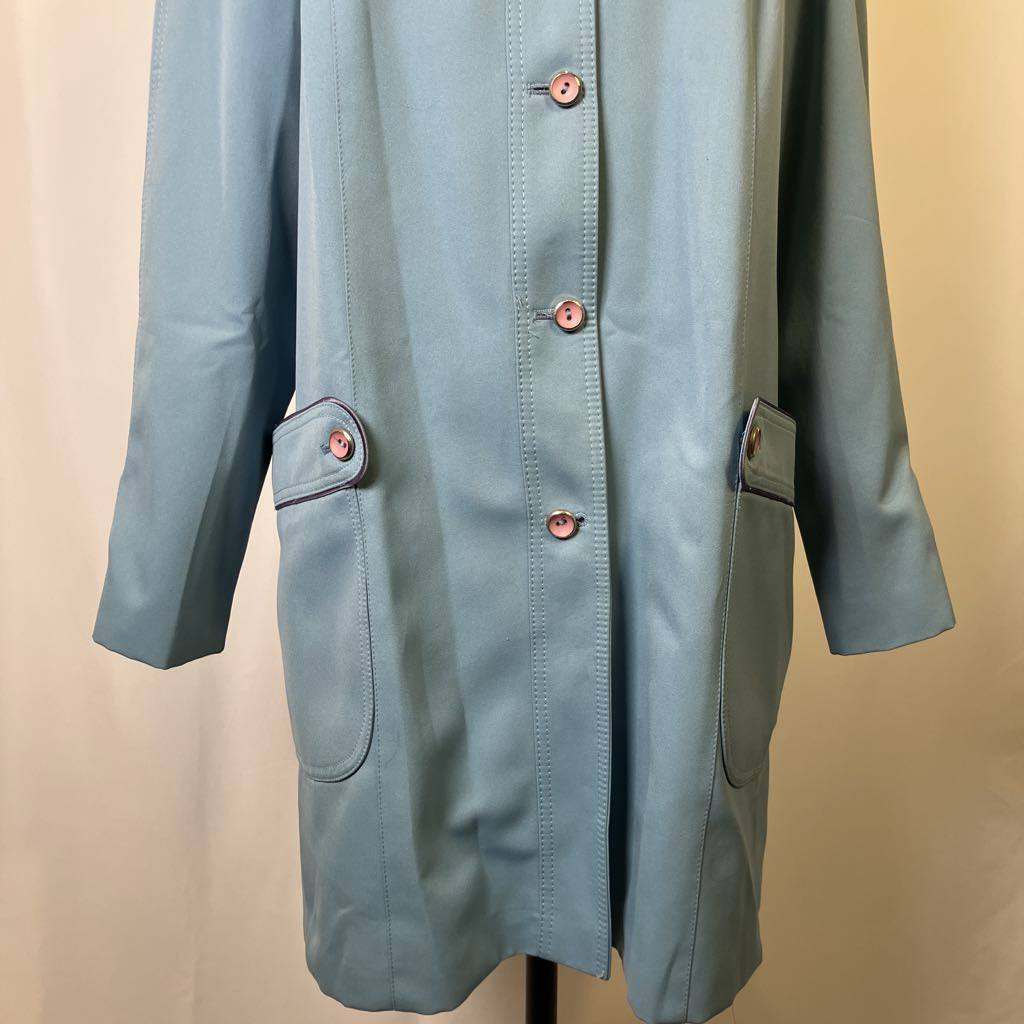 Light blue coat with buttons on a beige background