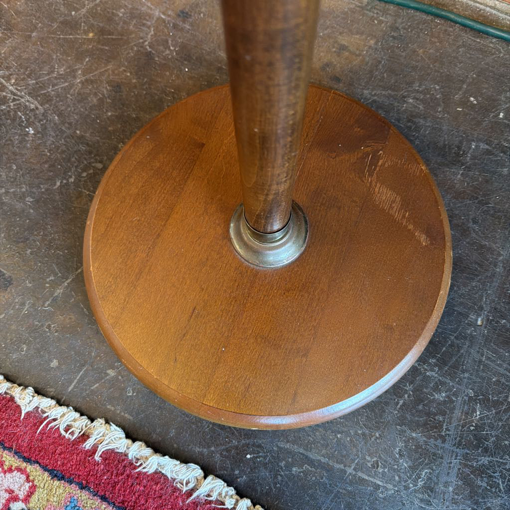 Wooden pedestal base on a textured floor