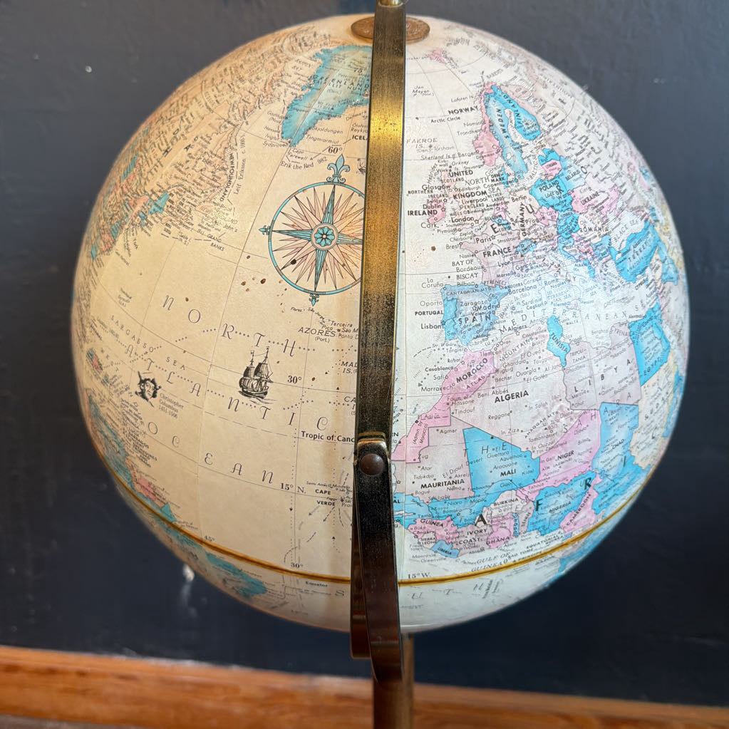 Vintage-style globe with a wooden stand on a dark background