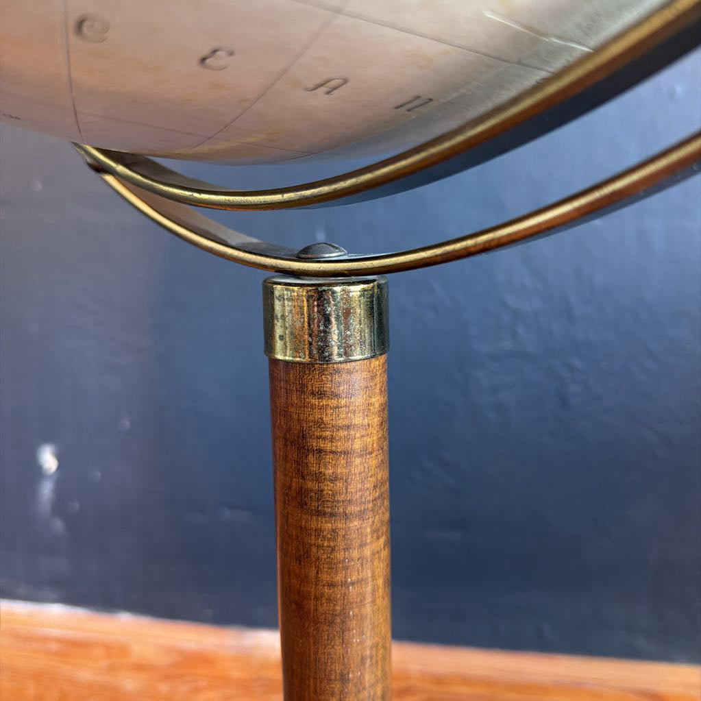 Wooden stand with gold metal arm against a dark blue background