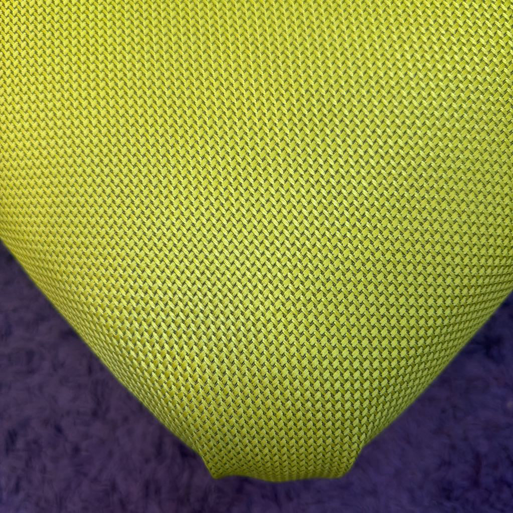 Close-up of a green textured fabric on a purple surface
