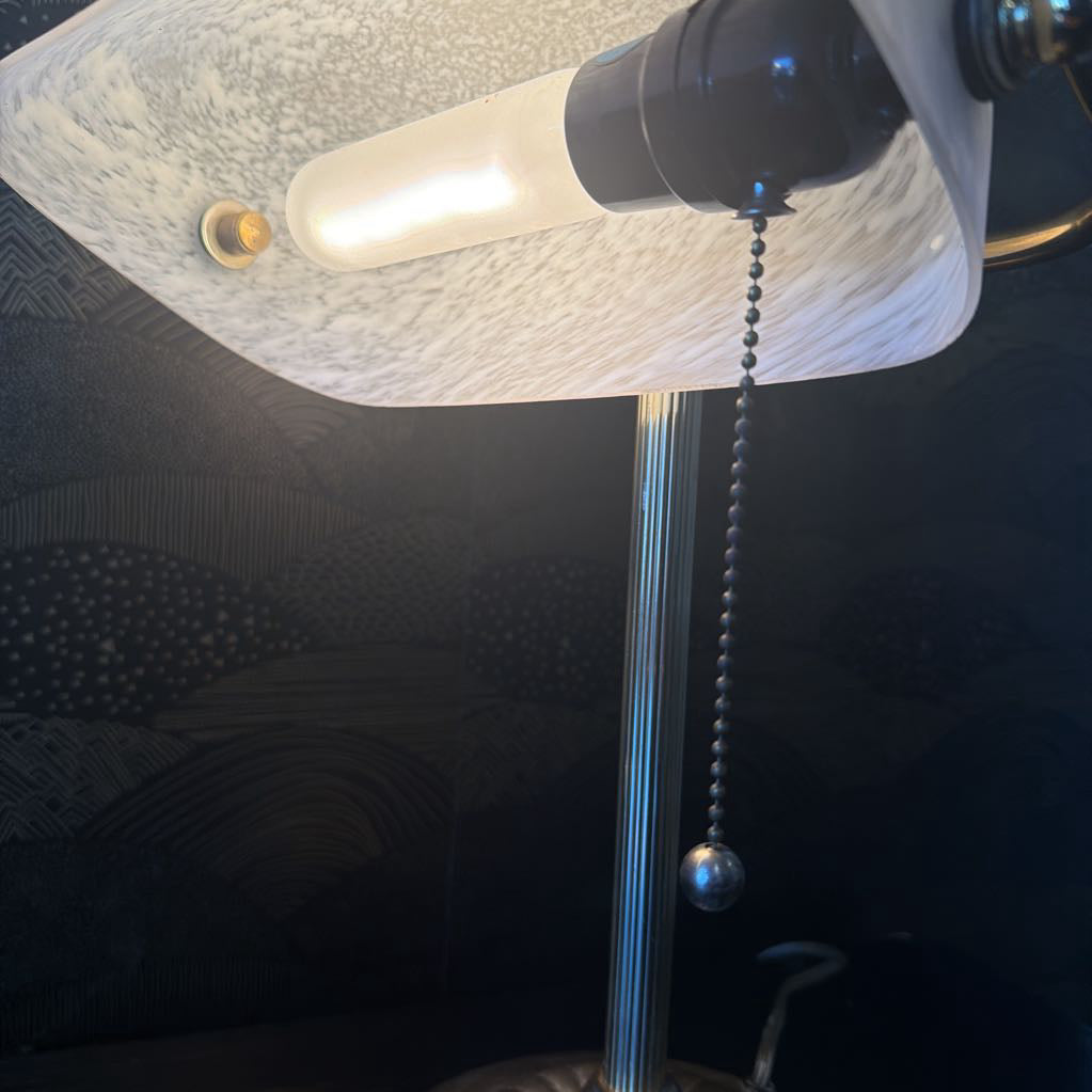 Close-up of a lamp with a textured shade and visible bulb against a dark background