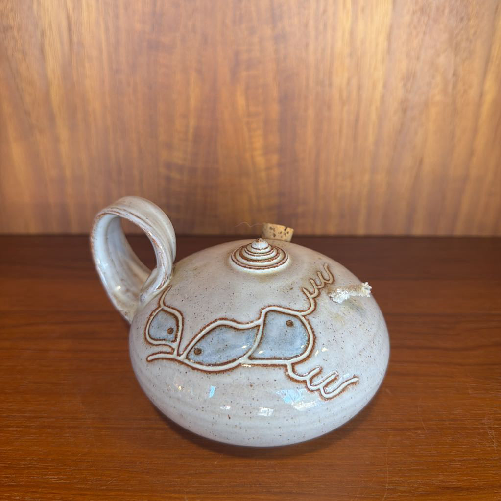Ceramic jar with decorative design on a wooden surface