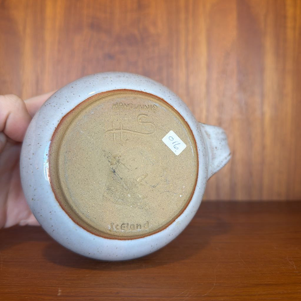 Ceramic mug with a visible brand logo on a wooden surface