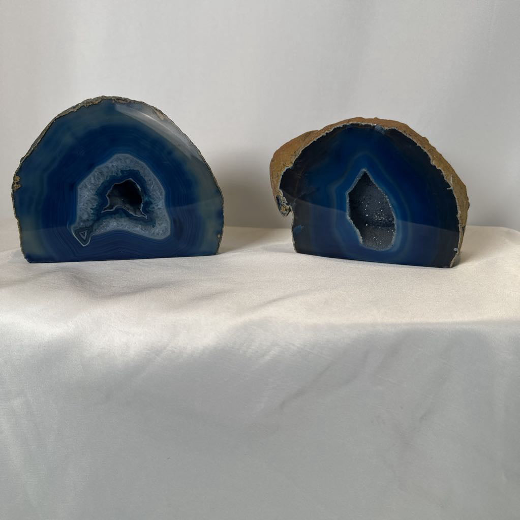 Two blue agate slices on a white surface with a white background