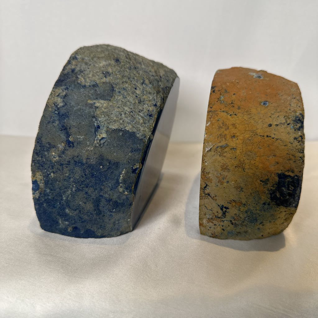 Two stone blocks with blue and rust-colored markings on a white background
