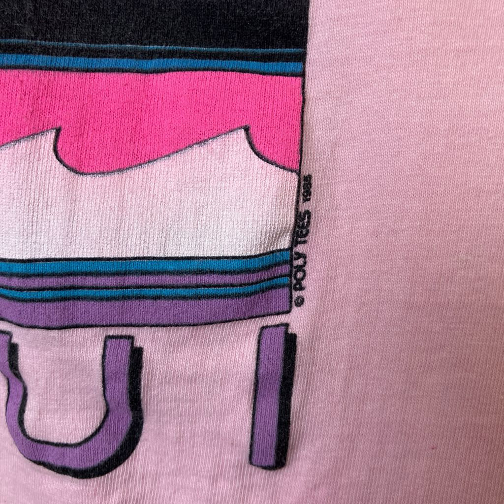 Close-up of a pink shirt with a cartoon character design and 'Poly Tees' logo.