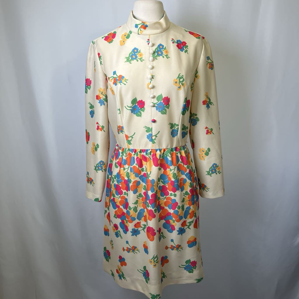 Colorful floral dress on a mannequin against a plain background