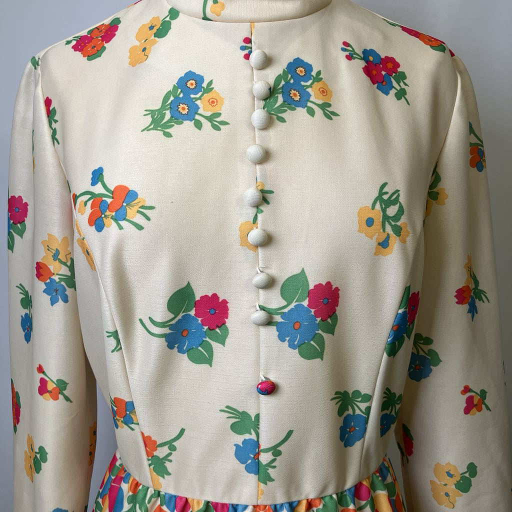 Beige cardigan with colorful floral patterns on a plain background