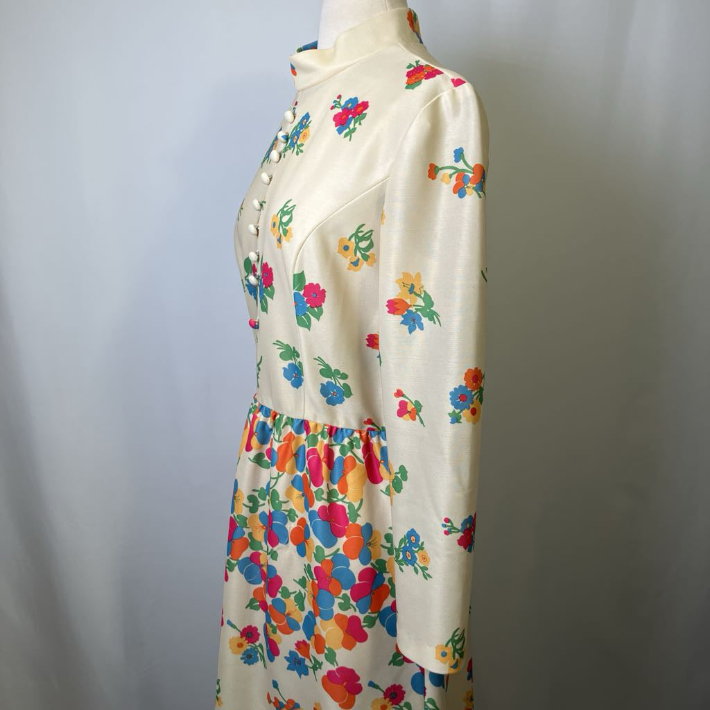 Mannequin wearing a cream dress with colorful floral pattern against a plain background