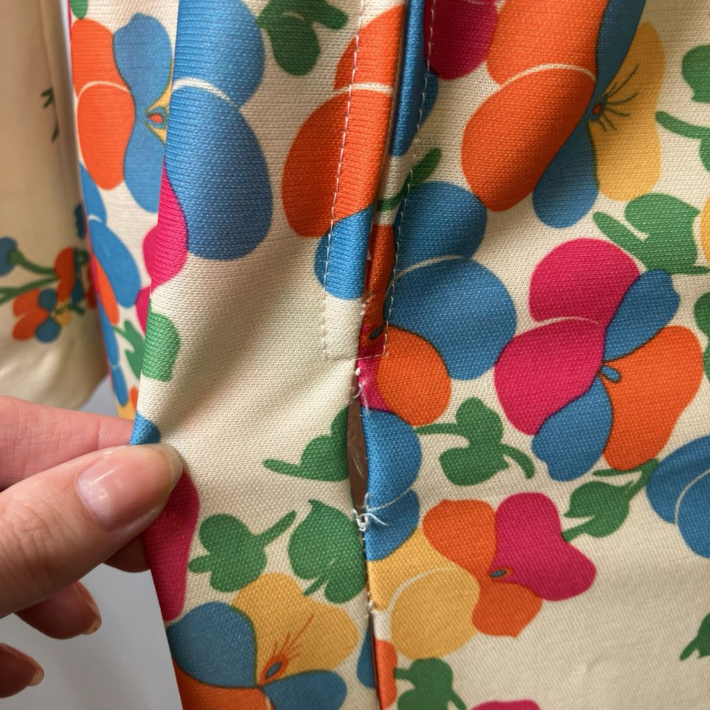 Close-up of colorful floral fabric with a hand holding it