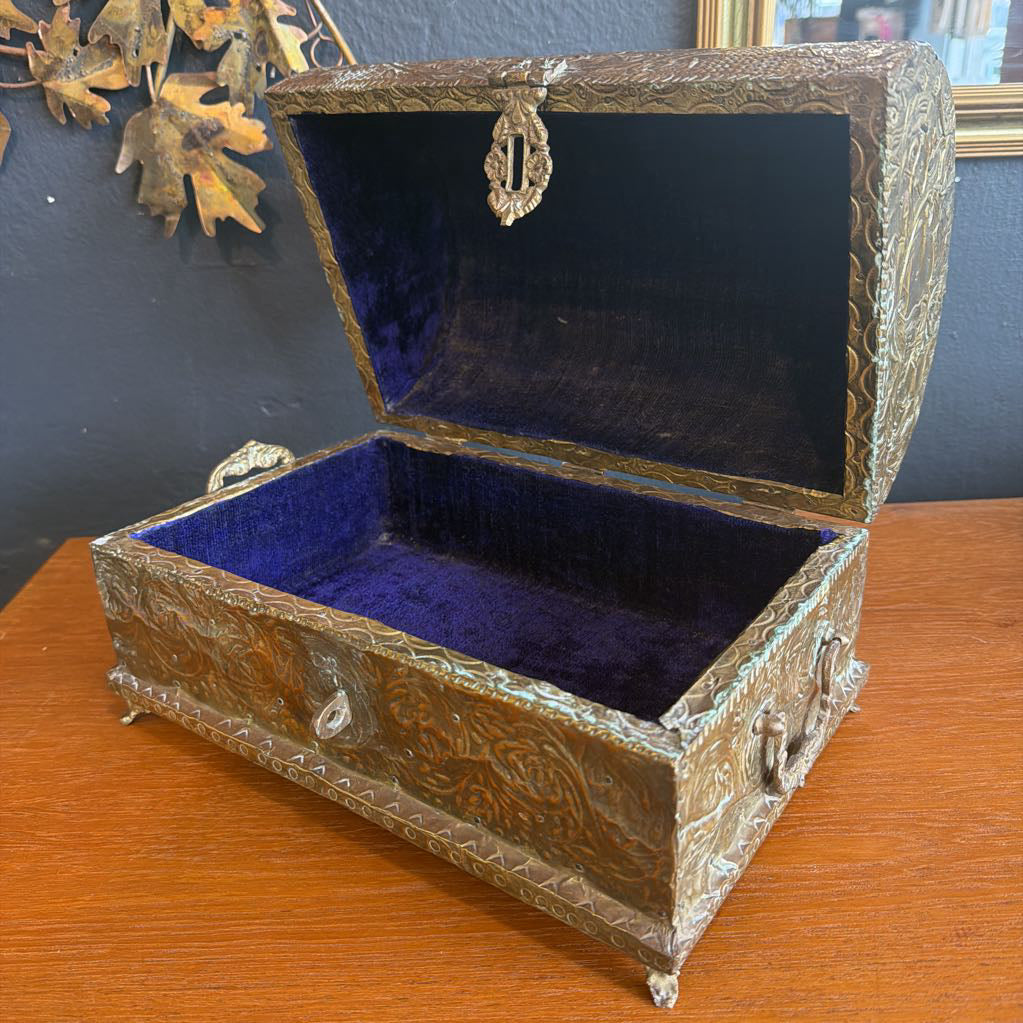 Decorative jewelry box with blue interior on a wooden surface