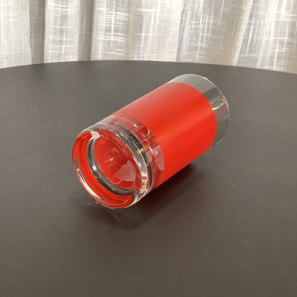 Red cylindrical glass on a dark surface