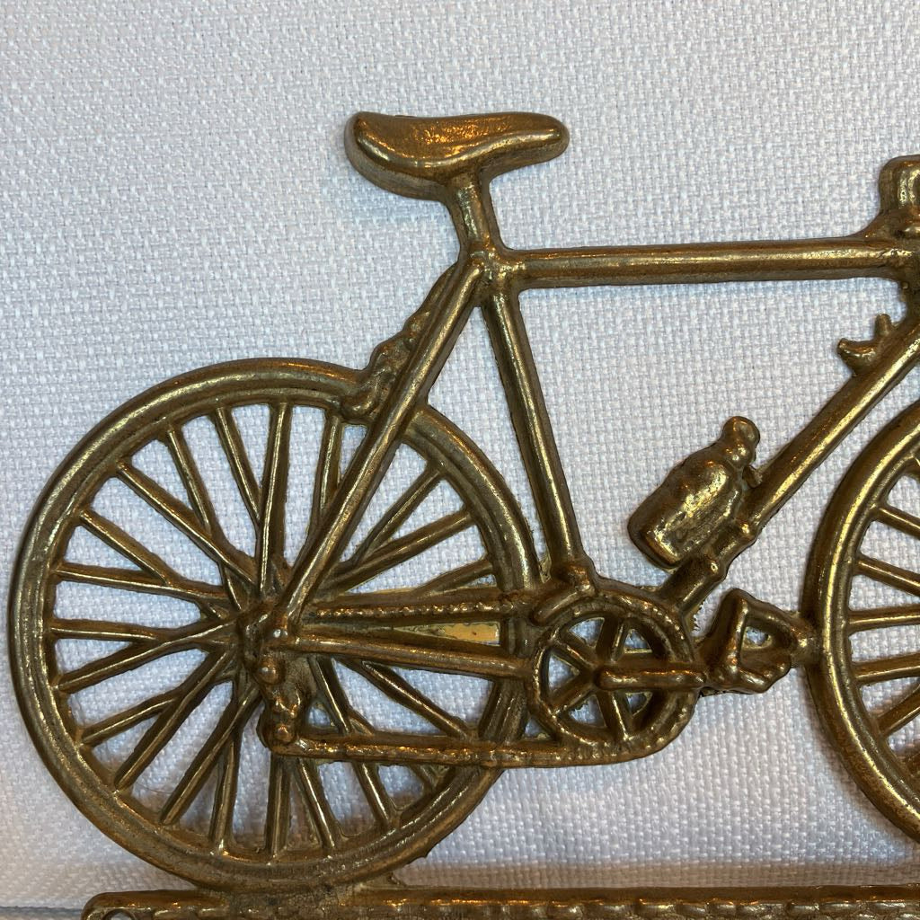 Bronze bicycle sculpture on a white background