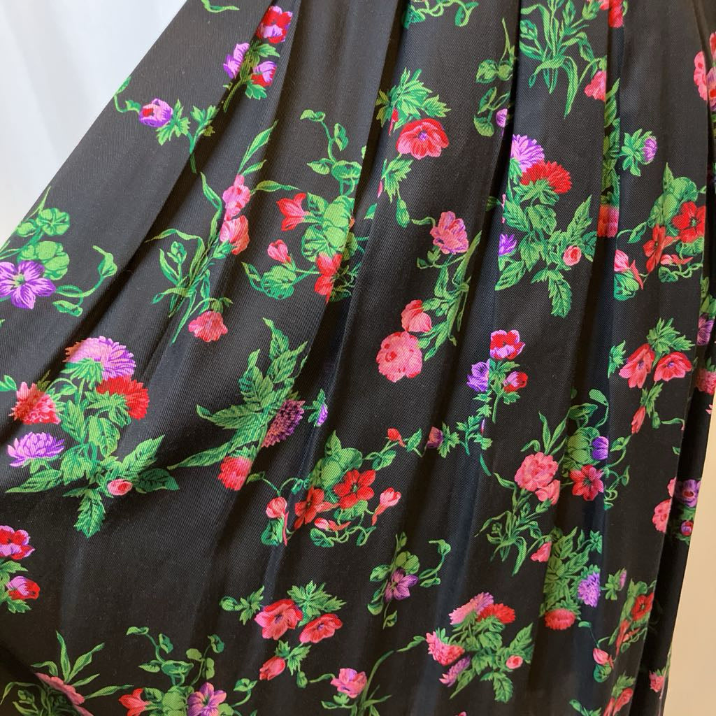 Floral patterned fabric with red, pink, and green flowers on a black background