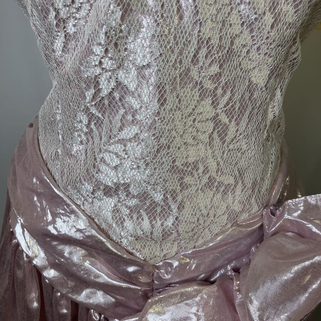 Close-up of a lace garment with a metallic finish on a plain background