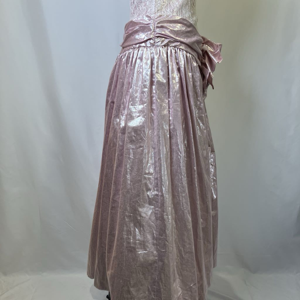 Mannequin wearing a long, shiny, metallic pink dress against a plain background