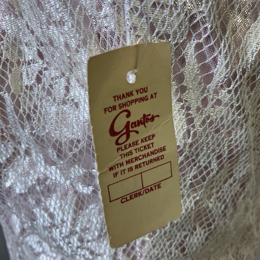 Gantes store tag on a textured fabric background
