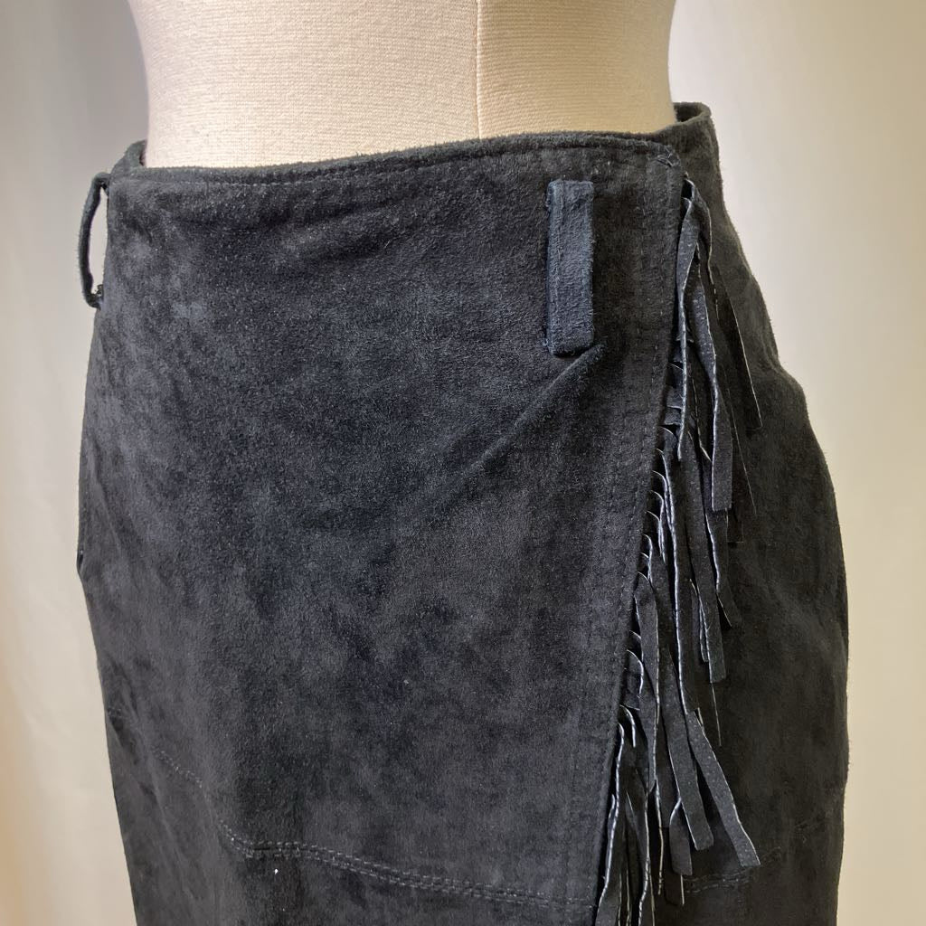 Black suede skirt with fringe on a mannequin against a neutral background