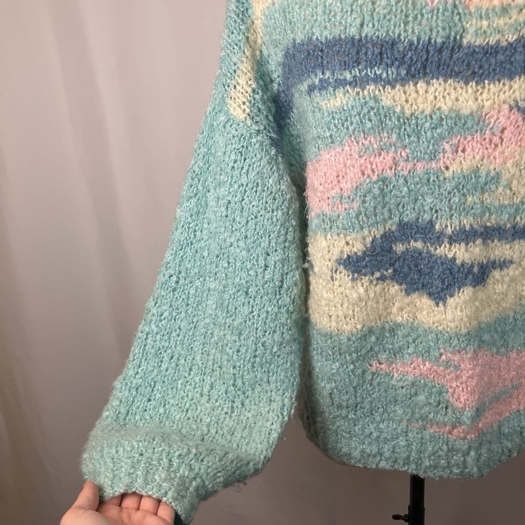 Close-up of a person wearing a colorful knitted sweater with abstract patterns.