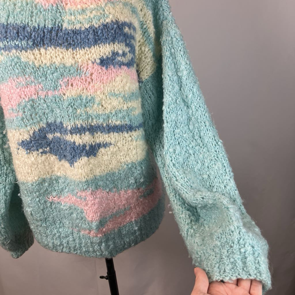 Pastel patterned sweater on a mannequin against a plain background