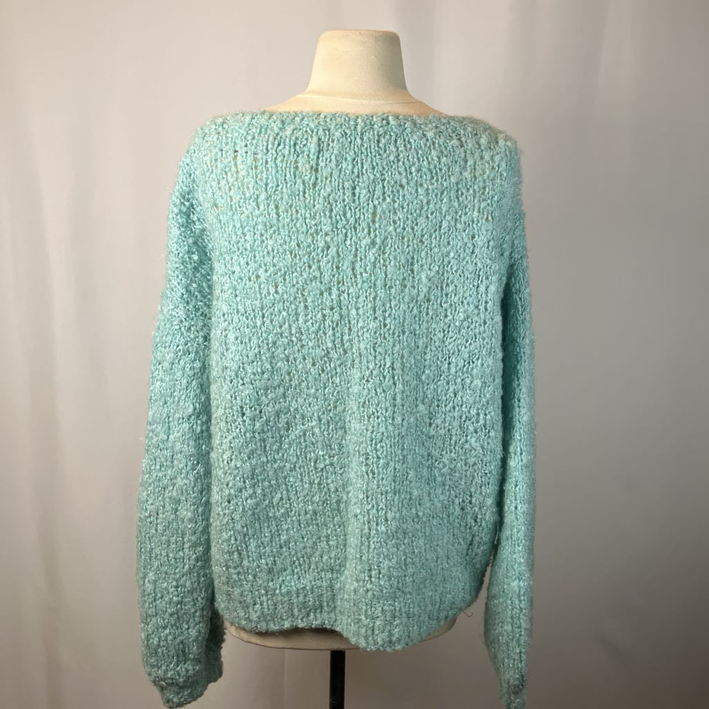 Teal knitted sweater on a mannequin against a plain background