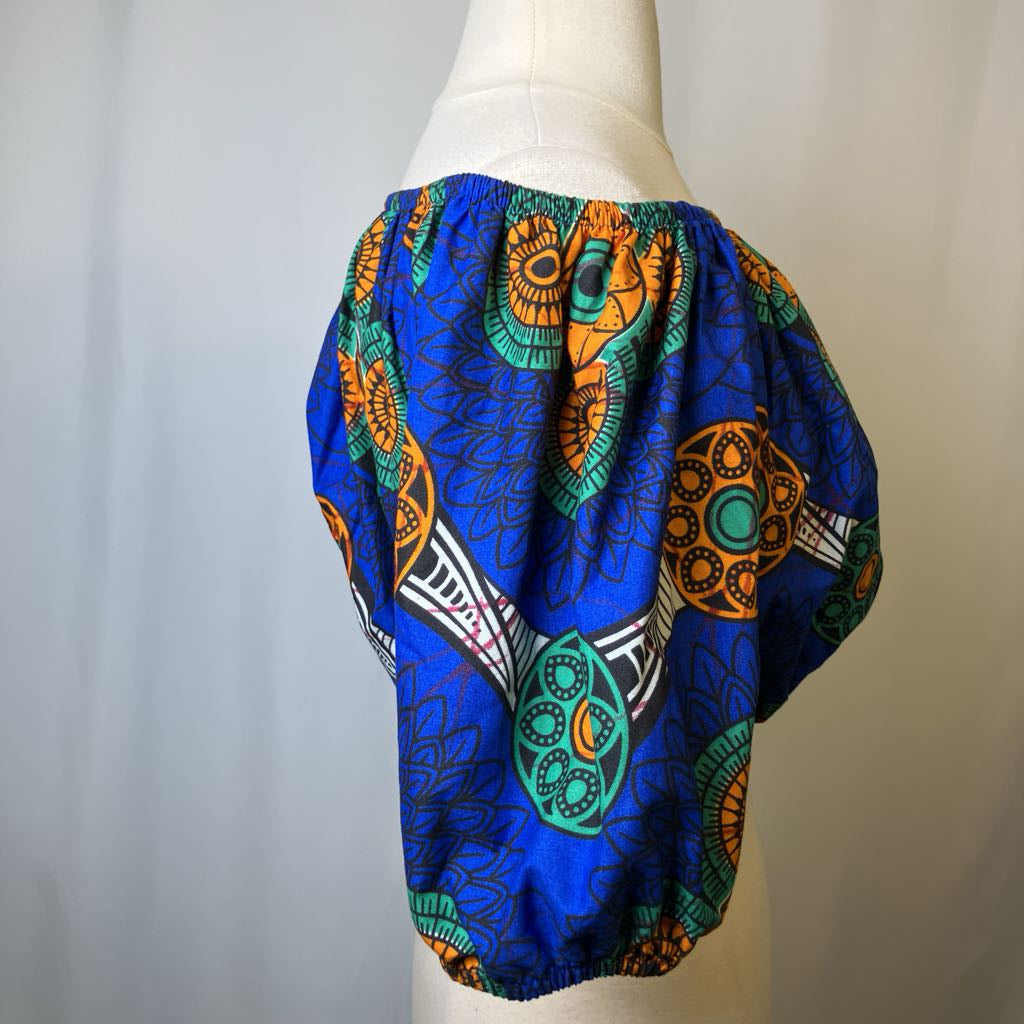 Colorful patterned fabric on a mannequin against a plain background