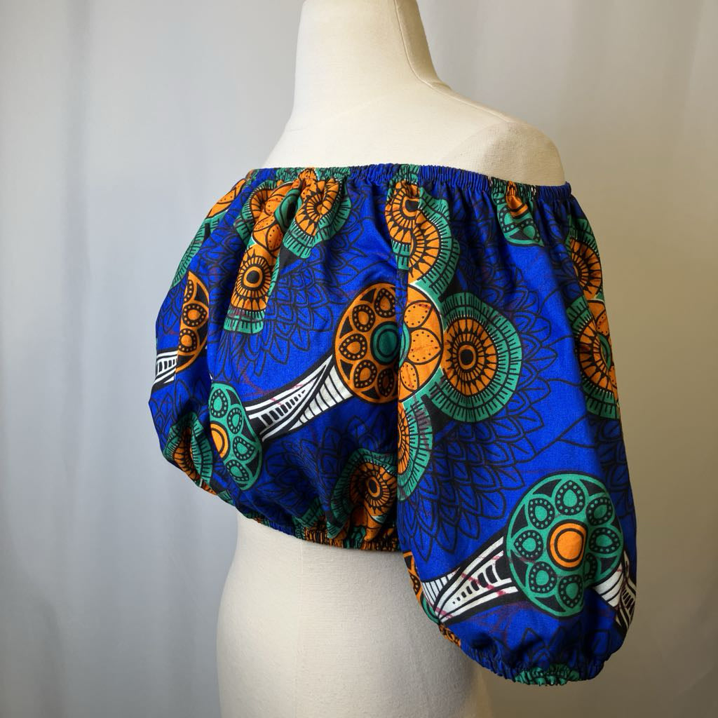 Colorful African print top on a mannequin against a plain background