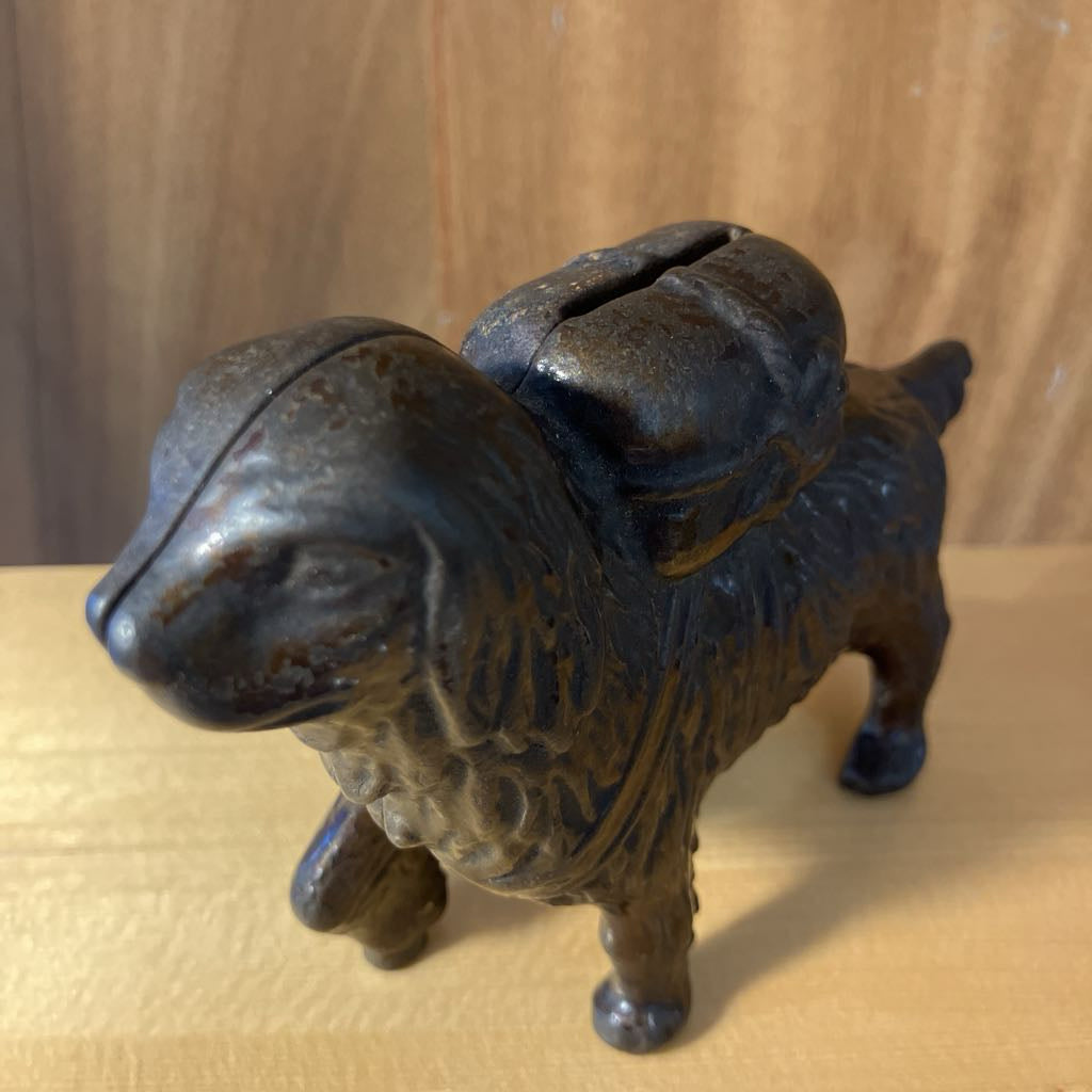 Cast iron dog-shaped piggy bank on a wooden surface