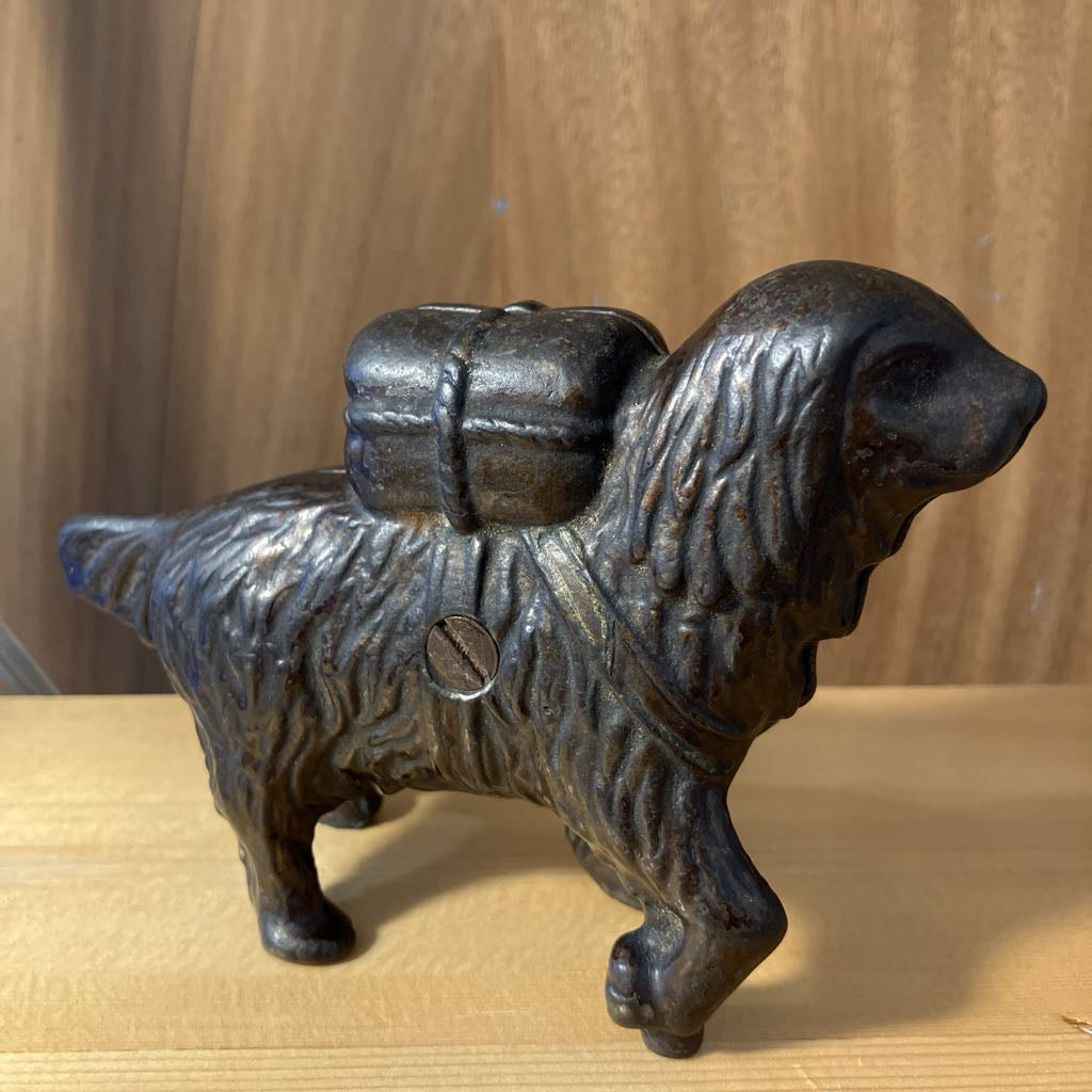 Cast iron dog-shaped container on a wooden surface with a wooden background