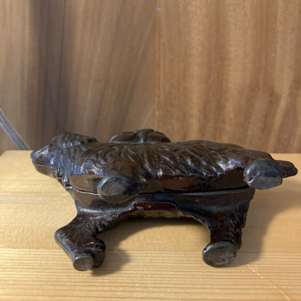 Decorative metal object on a wooden surface with a wooden panel background