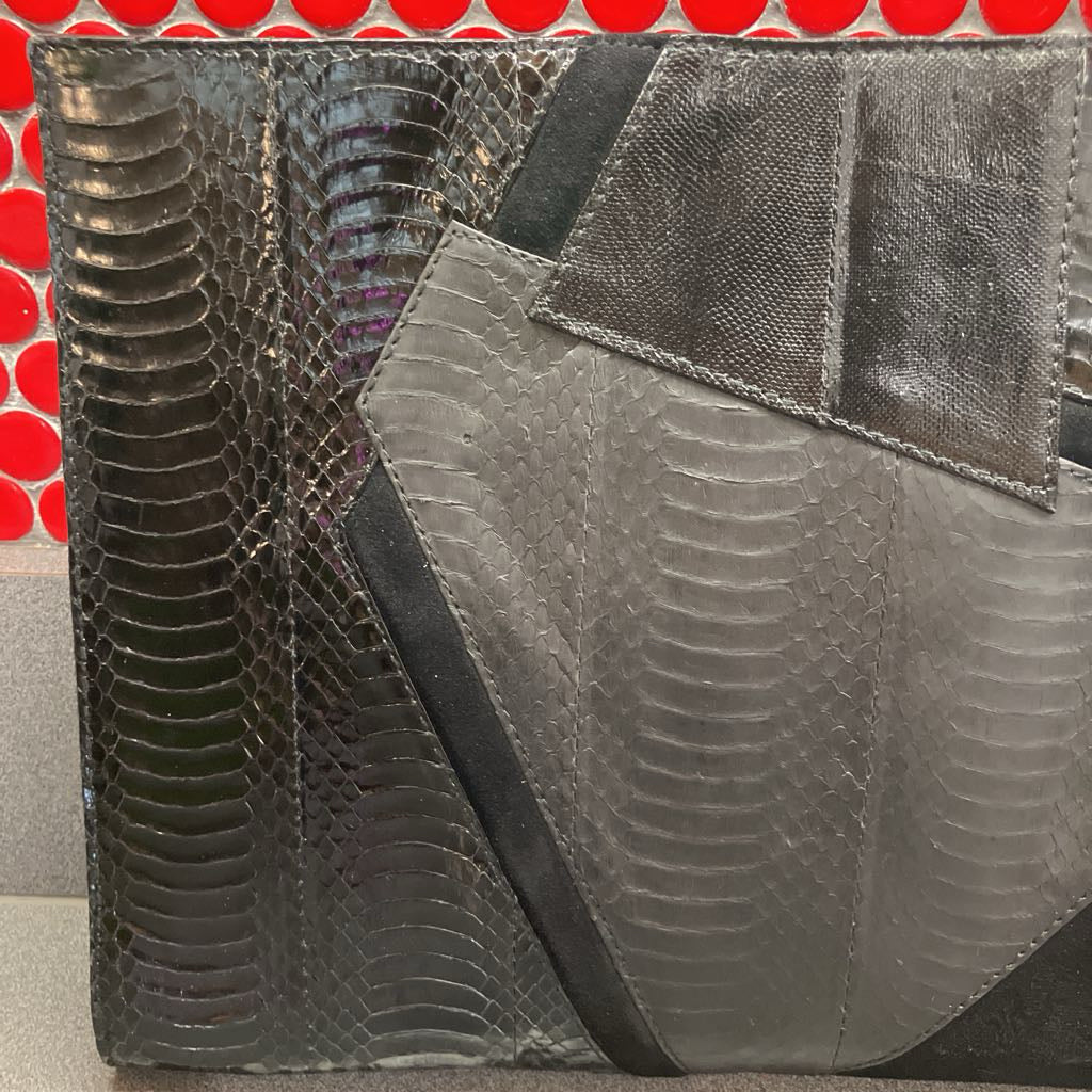 Gray textured clutch bag with a red and gray patterned background
