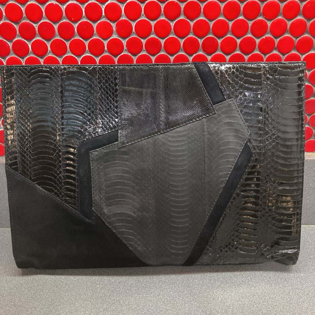 Black textured clutch bag on a red and gray background