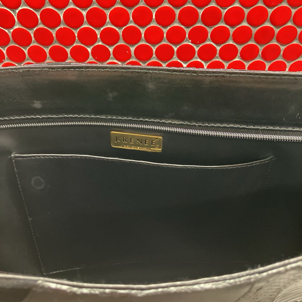 Black leather bag with a gold brand logo against a red circular patterned background