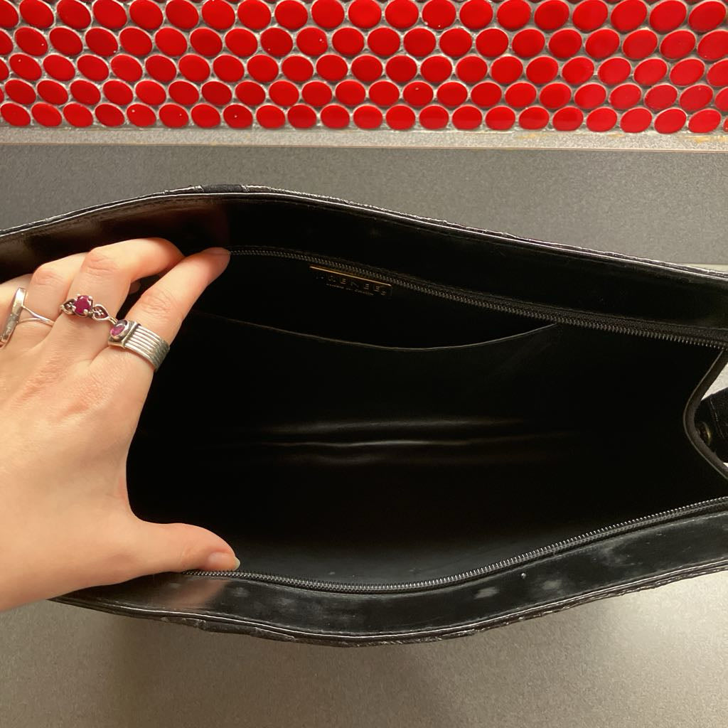 Hand opening a black bag with a red and gray background