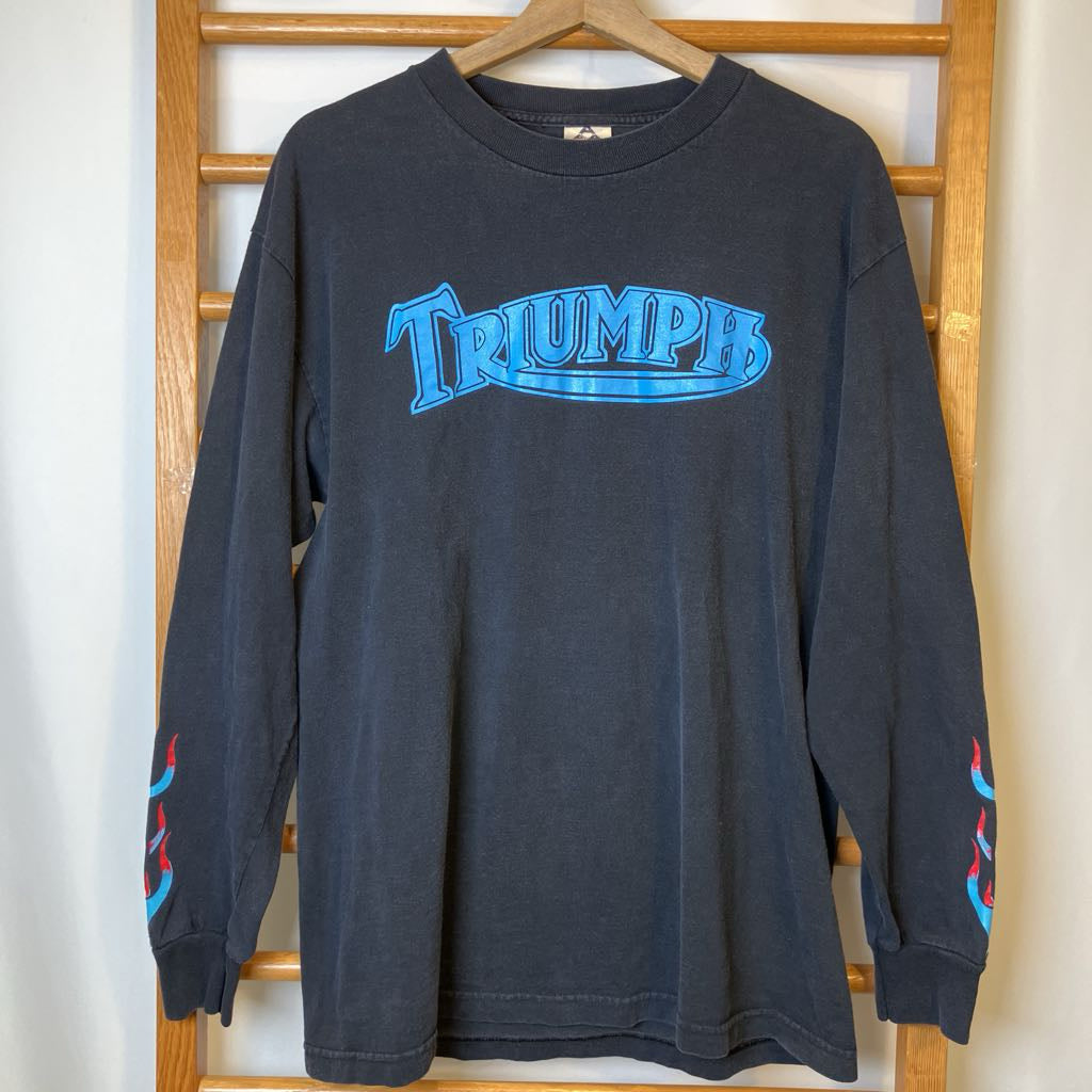 Black long-sleeve shirt with blue 'Triumph' logo on a wooden hanger.