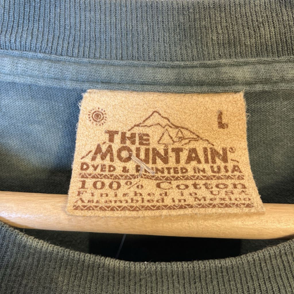 Label on a piece of clothing with 'The Mountain' branding and text about production details.