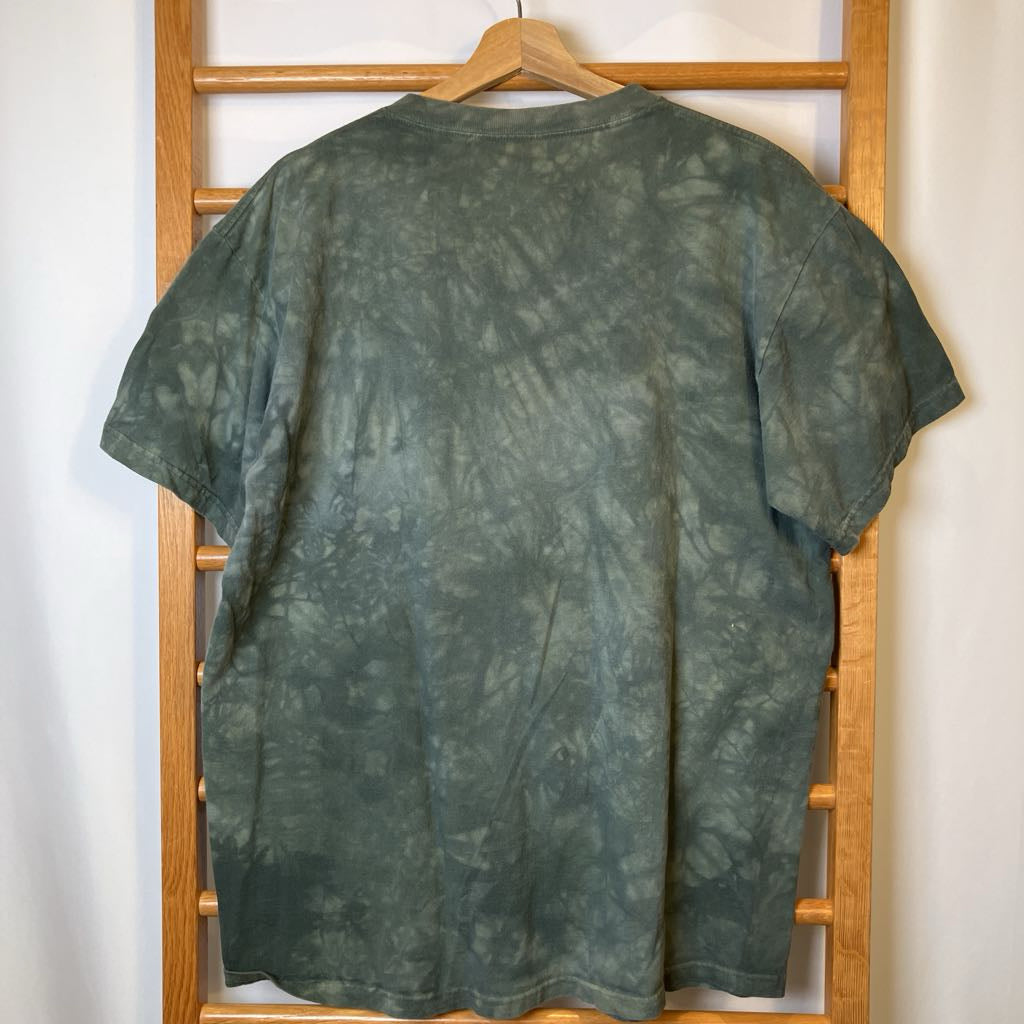 Green tie-dye t-shirt on a wooden hanger against a white wall