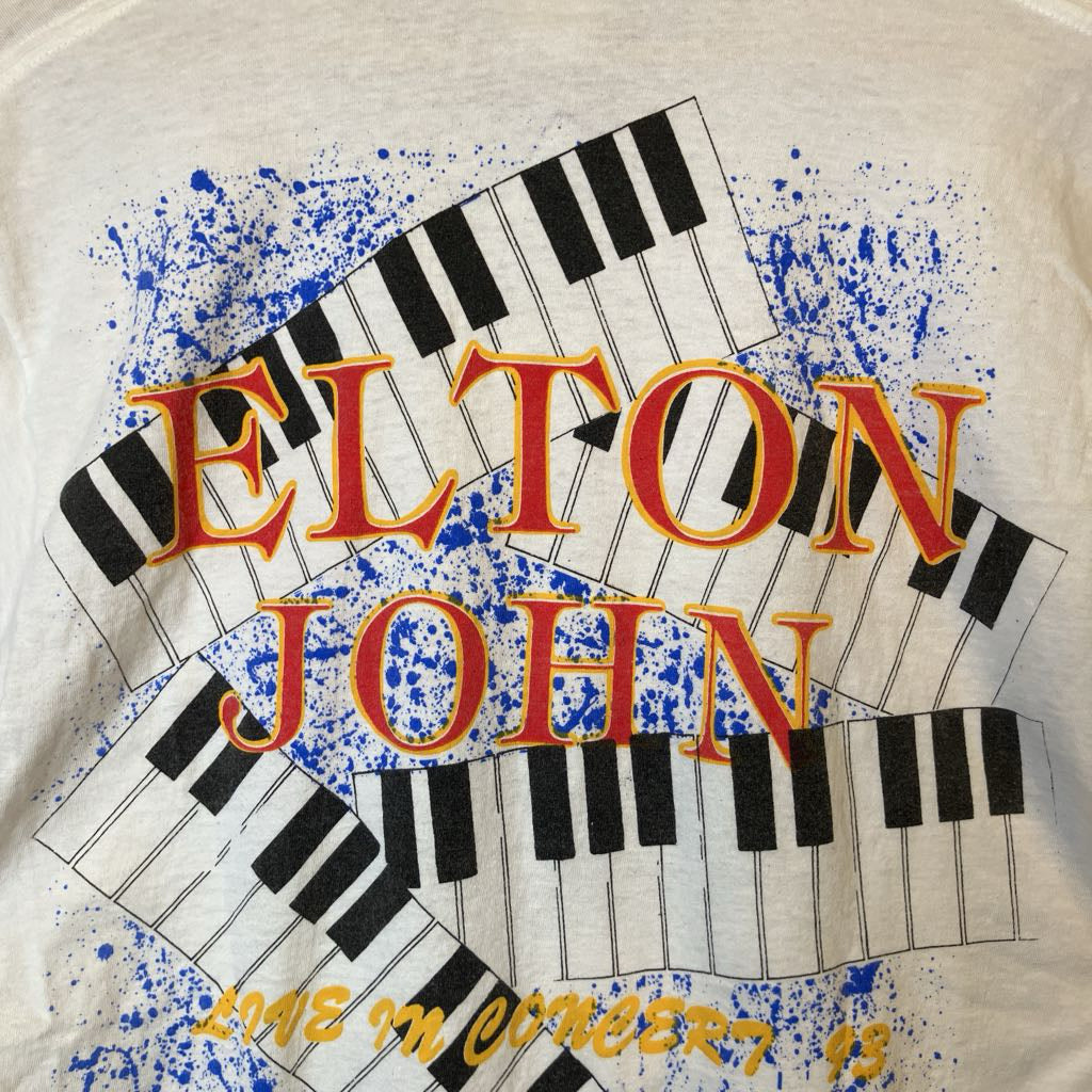 Elton John t-shirt with keyboard design and text on a white background