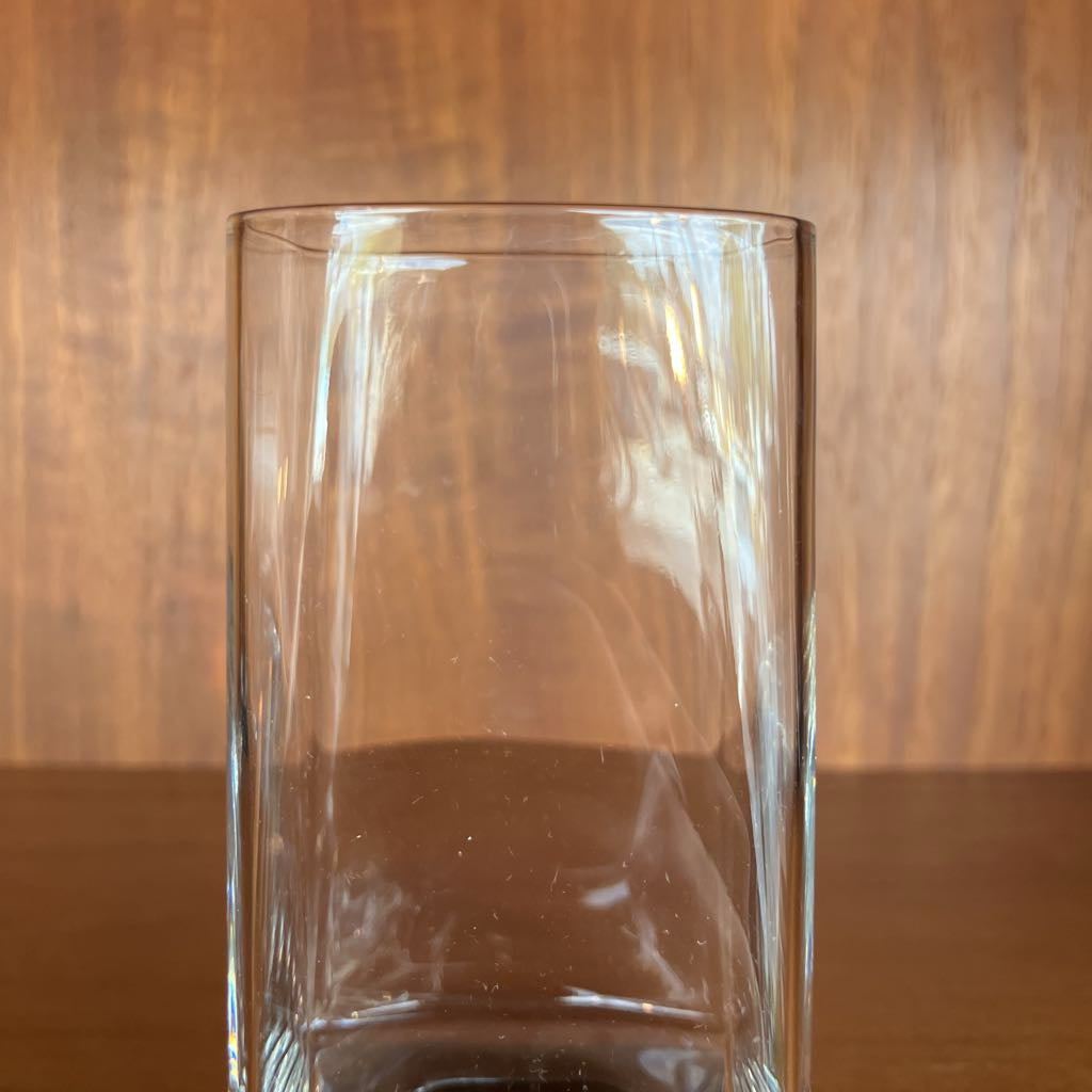 Clear bar glass on a wooden surface with a wooden background