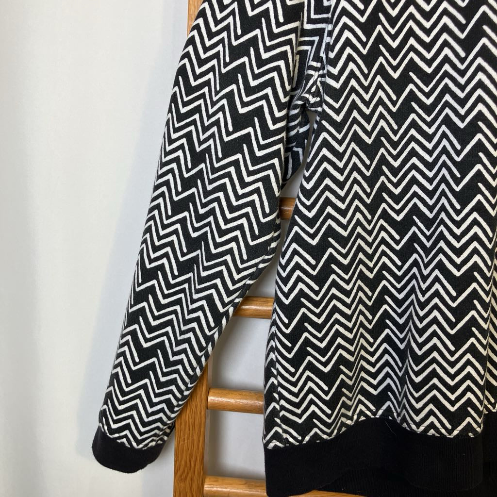 Black and white zigzag patterned fabric draped over a wooden chair against a white background